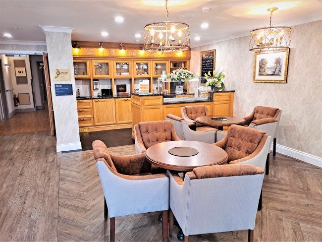 A view of the hotel dining room showcasing a bar and several chairs, creating a welcoming atmosphere for diners
