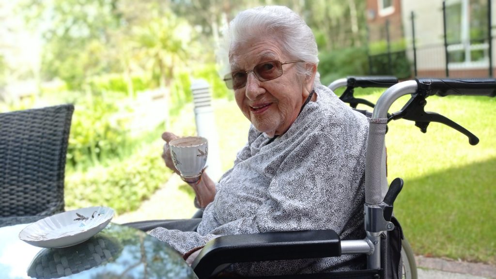 Resident of TLC Care Home, in Camberley Manor Care Home. Enjoying a cup of tea in the sunshine